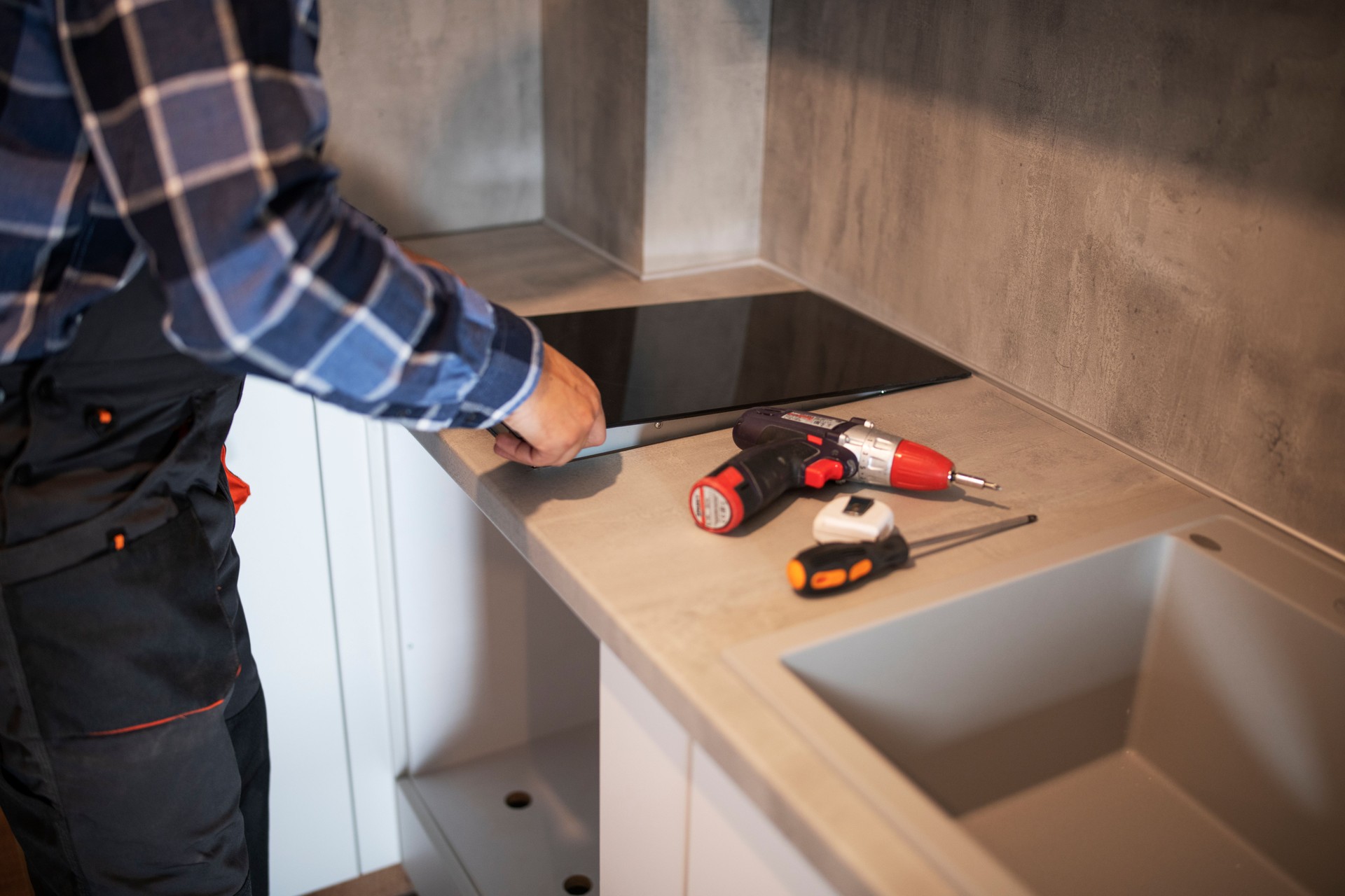 Man Installing Induction Hob In New Kitchen